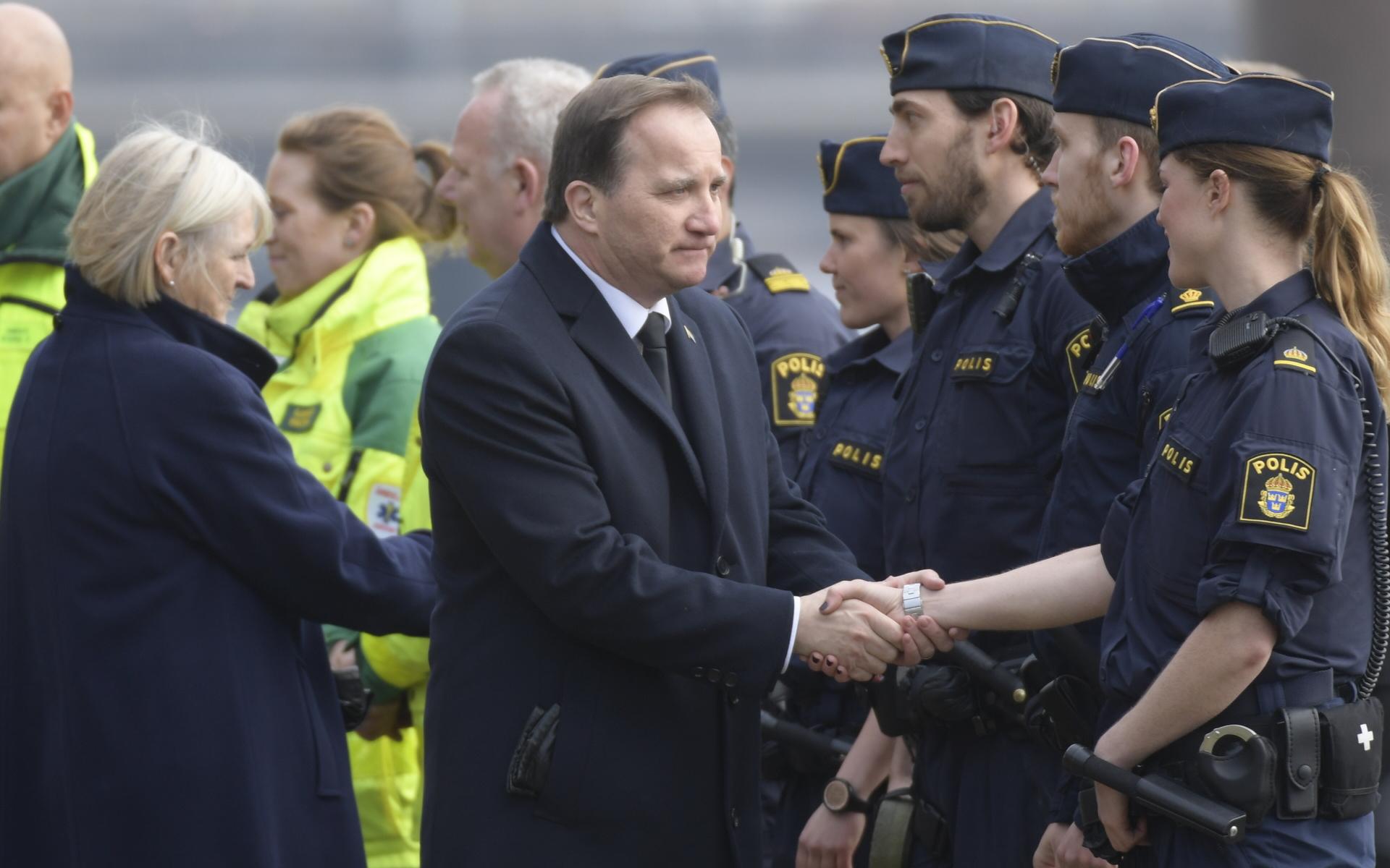 Dåvarande statsminister Stefan Löfven (S) hälsar på räddningspersonal under minnesstunden vid Stadshuset för att hedra offren.