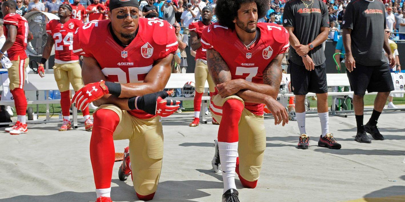 Colin Kaepernick, till höger, stämmer NFL för brott mot kollektivavtalet. Här knäböjer han under nationalsången tillsammans med Eric Reid, dåvarande lagkamrat i San Francisco. Arkivbild.