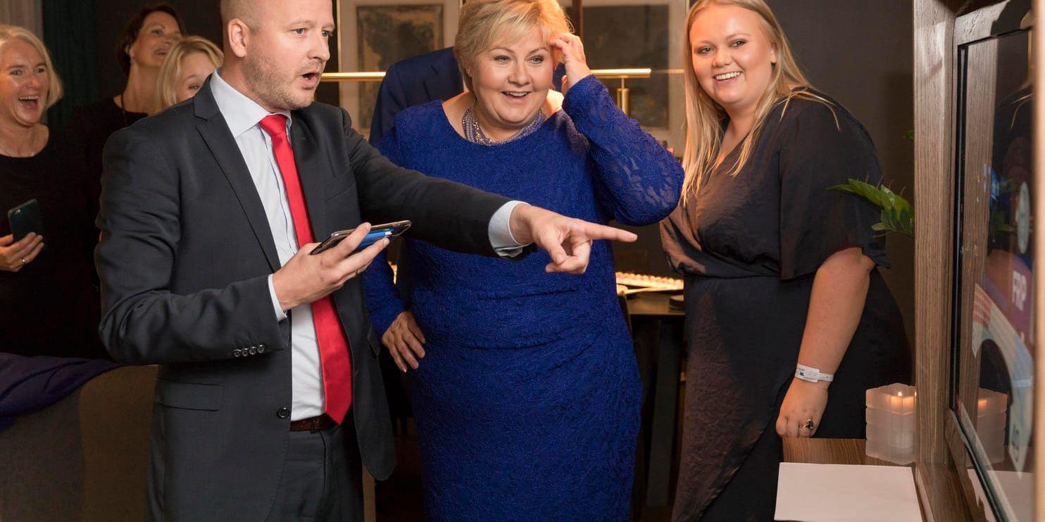 En glädjestrålande Erna Solberg tillsammans med dottern Ingrid Solberg och Sigbjørn Aanes tittar prognoserna på tv.