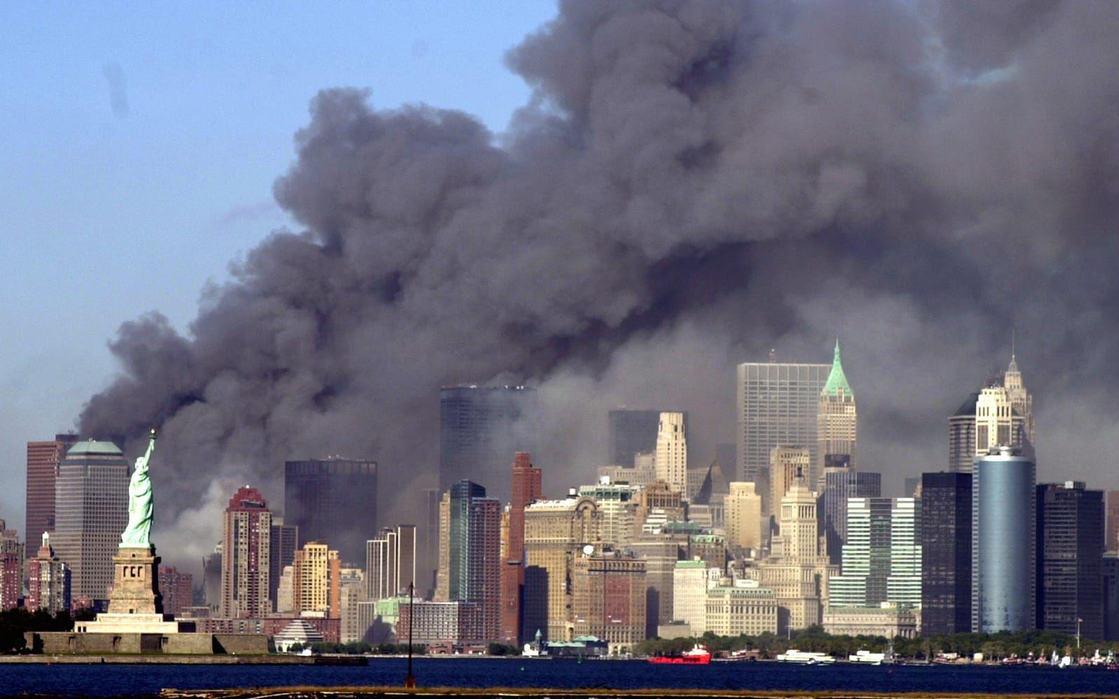 Tjock svart rök täckte området där World Trade Center-tornet stod för bara en liten stund sedan. Frihetsgudinnan i förgrunden. 